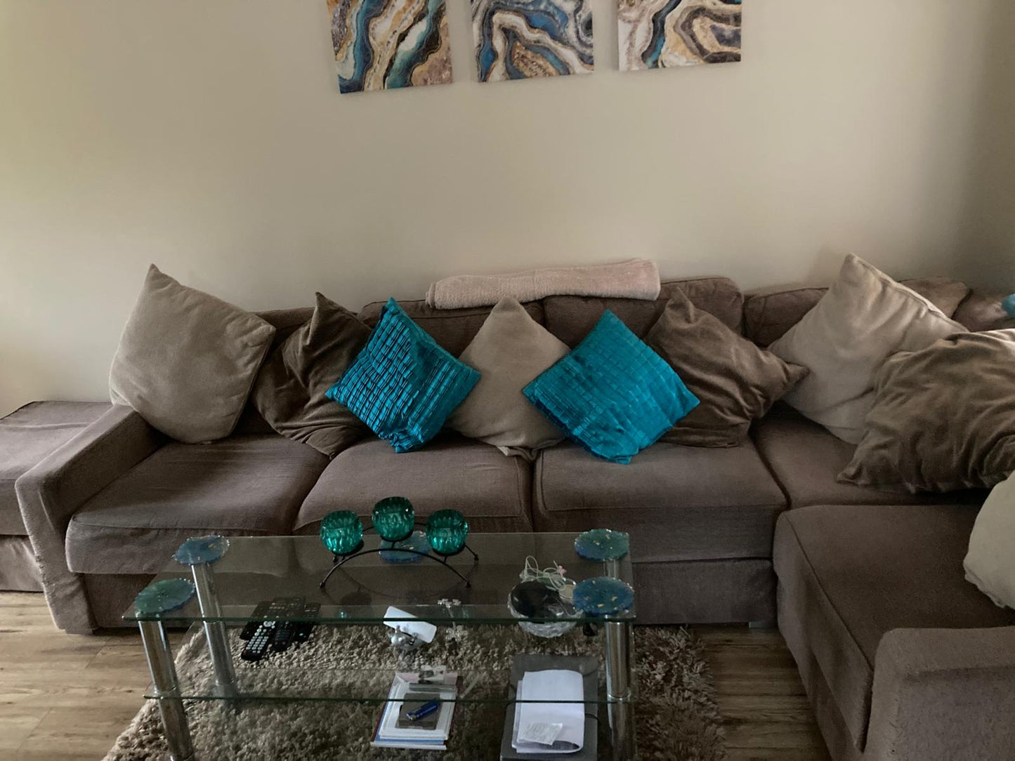 Handmade resin coasters blue/green pattern on a glass coffee table in front of a sofa